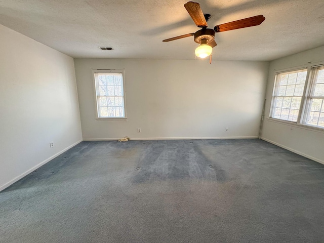 unfurnished room with visible vents, a textured ceiling, and baseboards