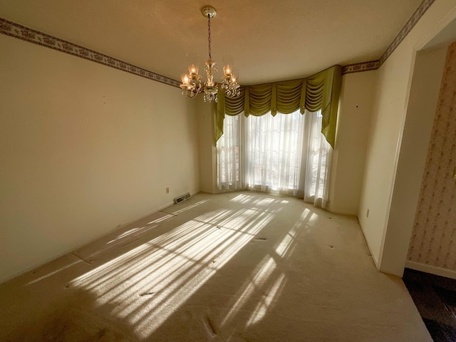 unfurnished room with visible vents and a chandelier