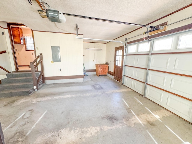 garage featuring electric panel, baseboards, and a garage door opener