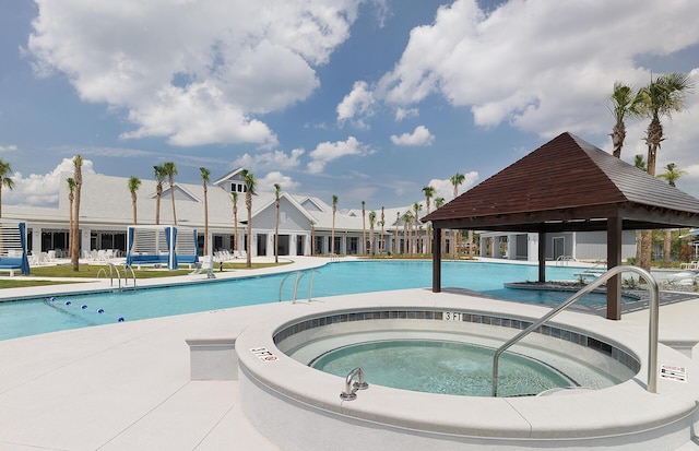 community pool with a gazebo, a hot tub, and a patio