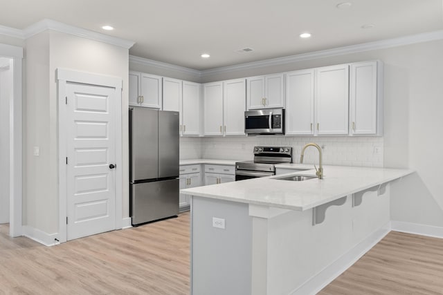 5133 Park Creek Ave, North Charleston, SC 29418 - kitchen featuring stainless steel appliances, a sink, a peninsula, a kitchen breakfast bar, and light wood-style floors