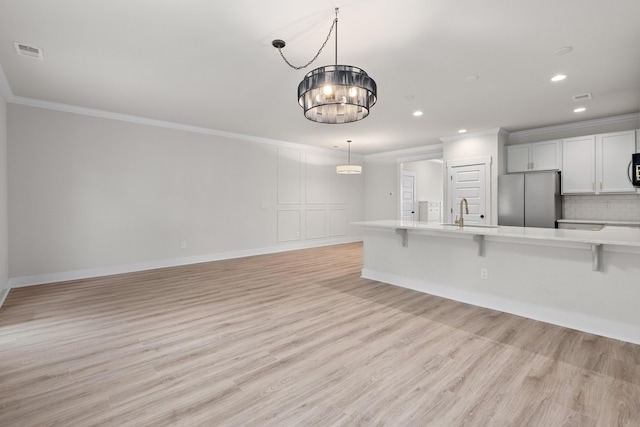 5133 Park Creek Ave, North Charleston, SC 29418 - kitchen featuring freestanding refrigerator, ornamental molding, a breakfast bar area, light countertops, and recessed lighting