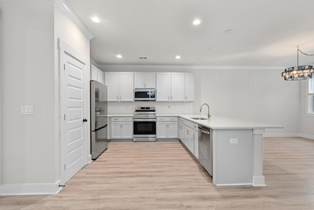 5133 Park Creek Ave, North Charleston, SC 29418 - kitchen featuring appliances with stainless steel finishes, a sink, decorative backsplash, a peninsula, and light wood-style flooring