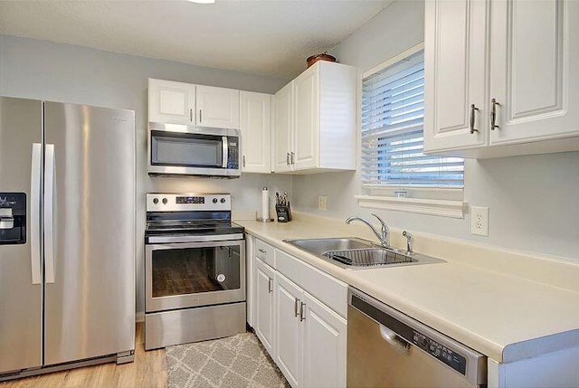 415 Parkdale Dr Unit 6D, Charleston, SC 29414 - kitchen with appliances with stainless steel finishes, white cabinetry, light countertops, and light wood-style floors