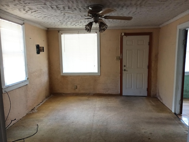 spare room featuring ceiling fan, crown molding, and a textured ceiling