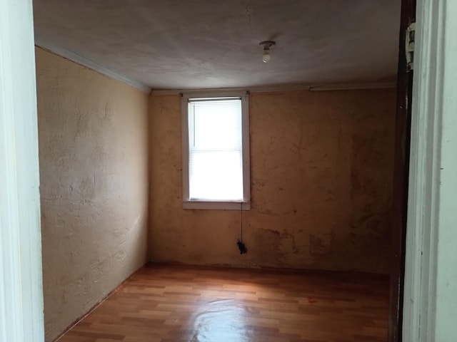 unfurnished room featuring light wood-type flooring and ornamental molding