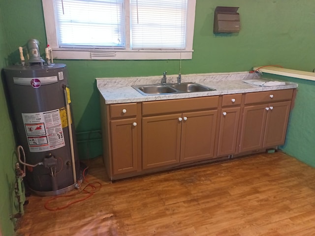 bathroom featuring wood-type flooring, gas water heater, and sink