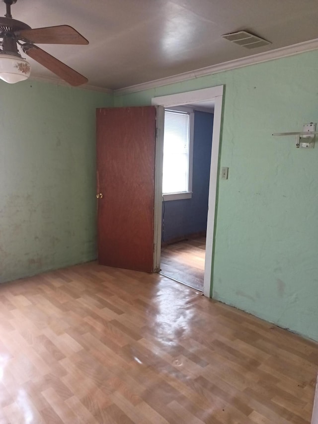 spare room with ceiling fan, crown molding, and light hardwood / wood-style flooring