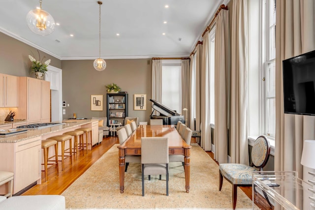 dining space with recessed lighting, crown molding, and light wood-style flooring