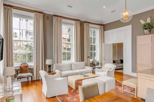 living room with light wood finished floors, plenty of natural light, and visible vents