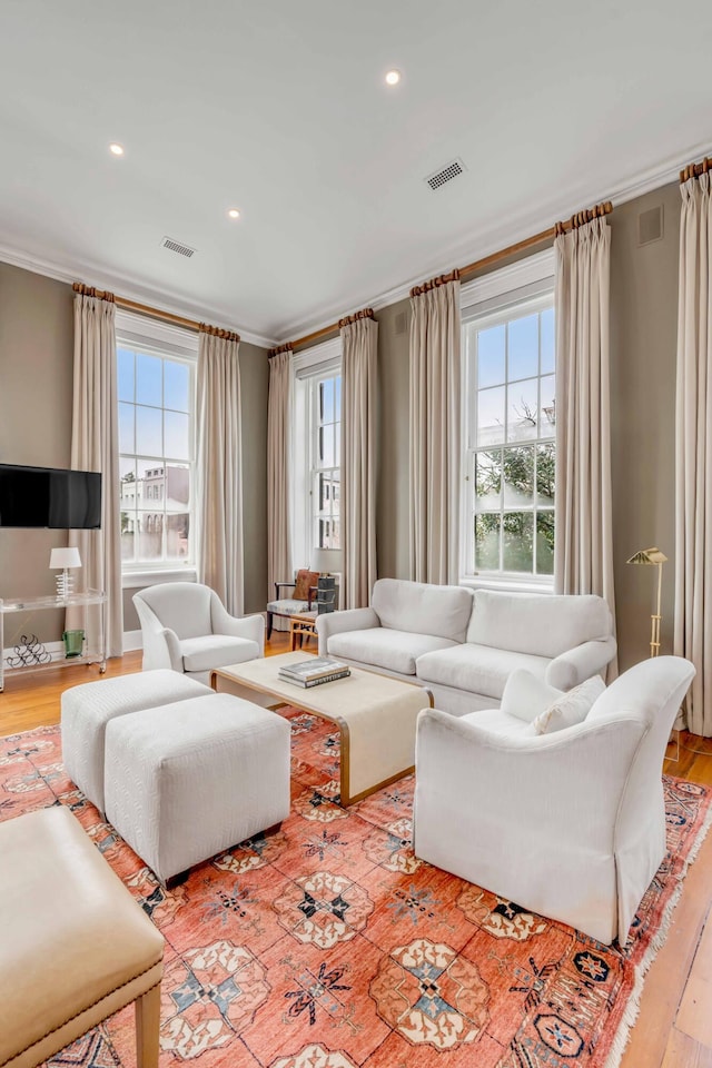 living room featuring ornamental molding, a wealth of natural light, and visible vents