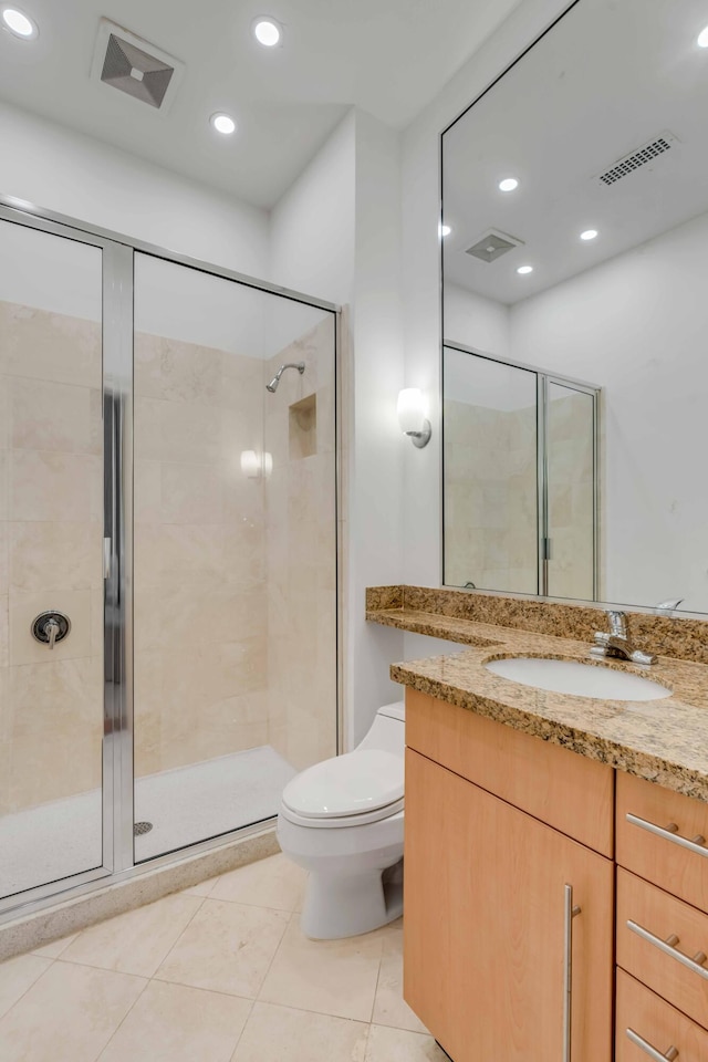 full bathroom featuring toilet, a shower stall, and visible vents