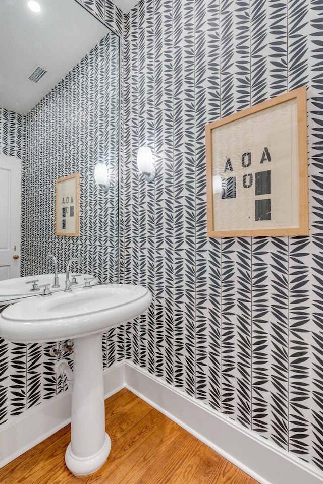 bathroom with wood finished floors, visible vents, and baseboards