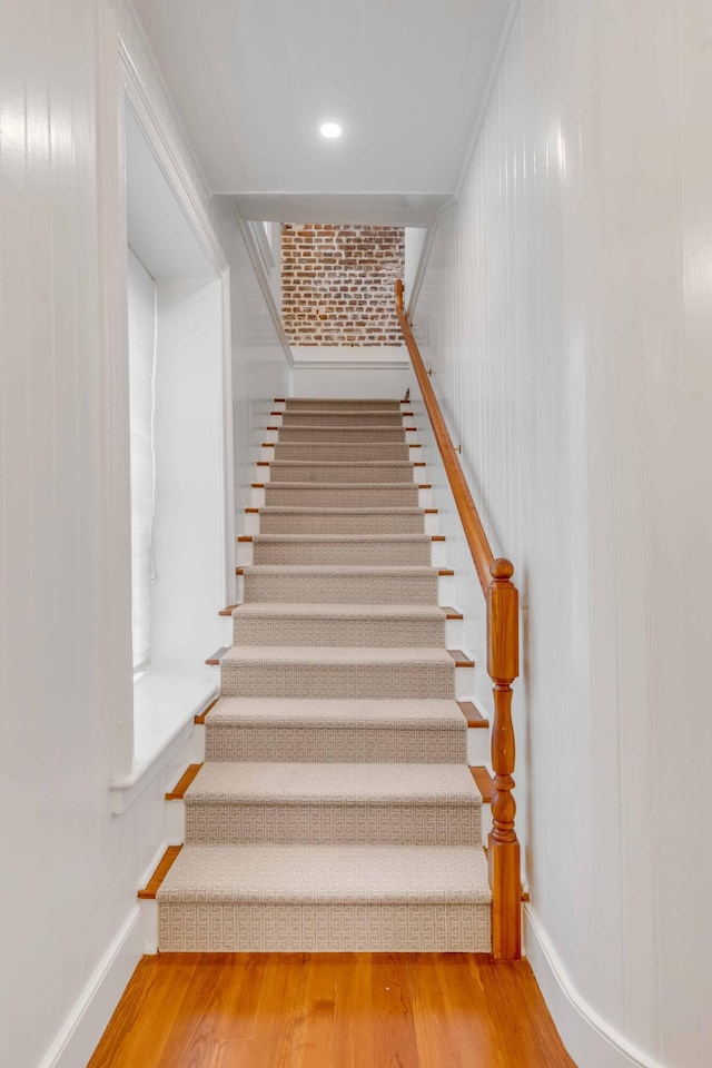 stairway with baseboards and wood finished floors