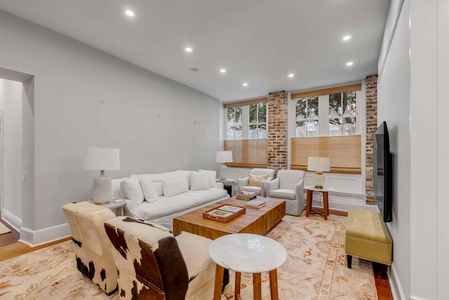 living room featuring recessed lighting, baseboards, and light wood finished floors