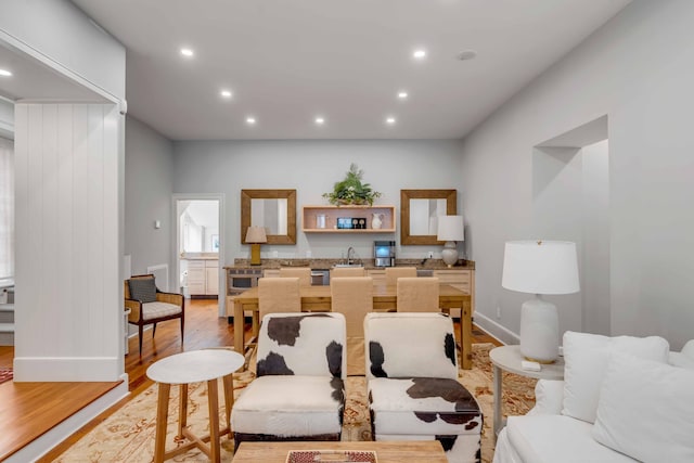 living room featuring recessed lighting, baseboards, and light wood finished floors