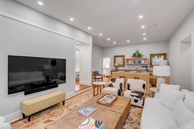 living room featuring light wood-style floors, baseboards, and recessed lighting