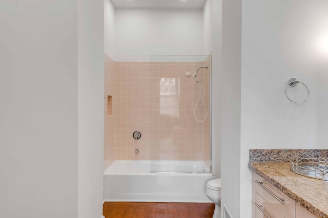 bathroom with shower / bathtub combination, toilet, wood finished floors, and vanity