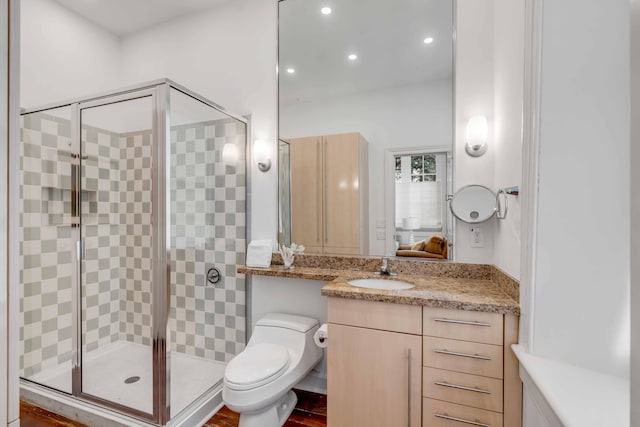 bathroom featuring toilet, ensuite bathroom, vanity, a shower stall, and recessed lighting