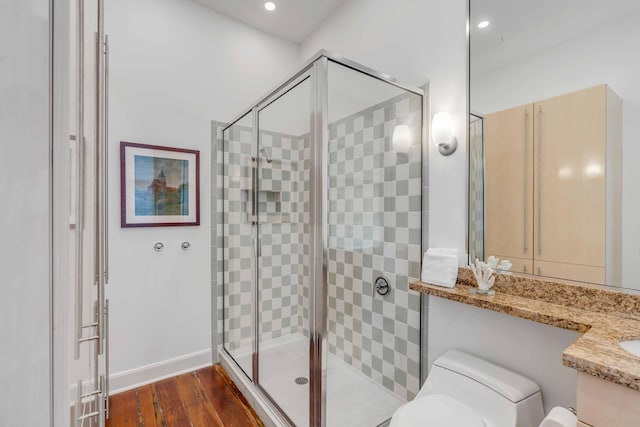 full bathroom with toilet, a stall shower, wood finished floors, and vanity