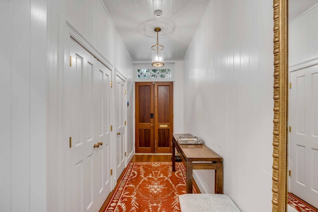 entryway featuring ornamental molding and wood finished floors