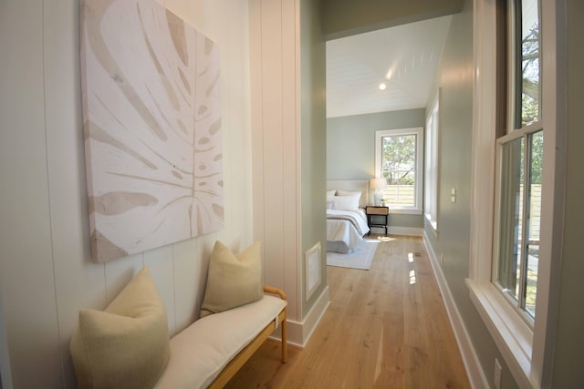 corridor with baseboards and wood finished floors