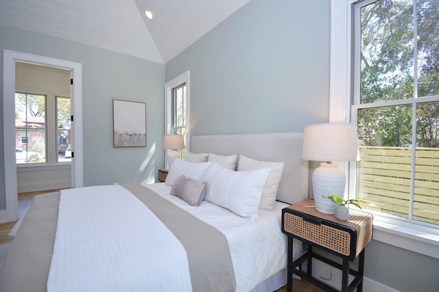 bedroom with lofted ceiling and wood finished floors