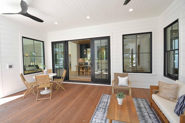 wooden deck featuring outdoor dining space and a ceiling fan