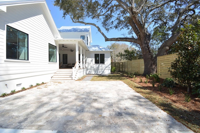 exterior space with crawl space, ceiling fan, and fence