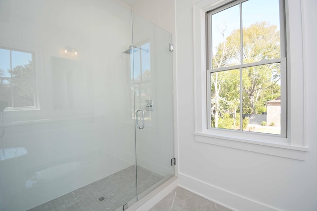 bathroom featuring a stall shower and baseboards