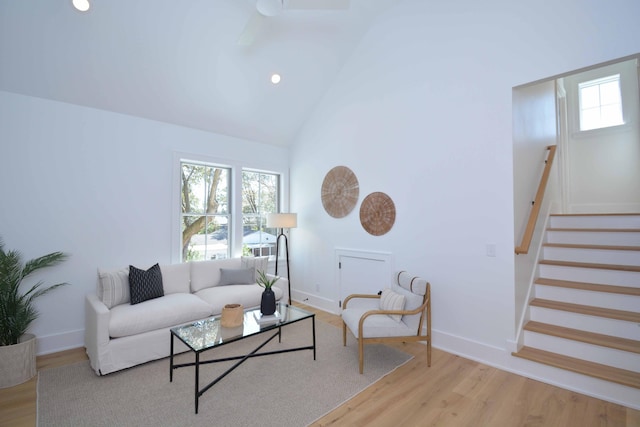 living room featuring baseboards, stairs, recessed lighting, wood finished floors, and high vaulted ceiling