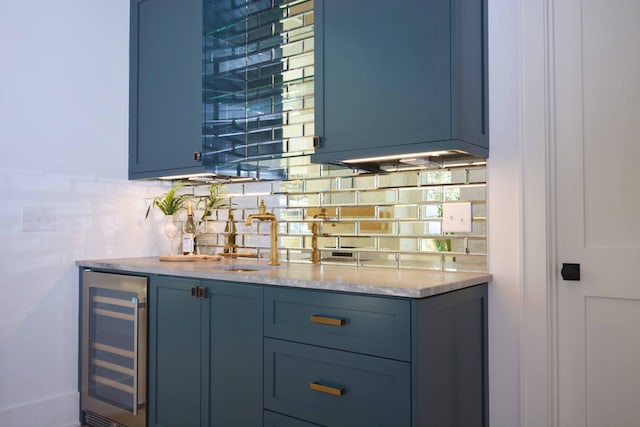 bar with a sink, indoor wet bar, tasteful backsplash, and beverage cooler