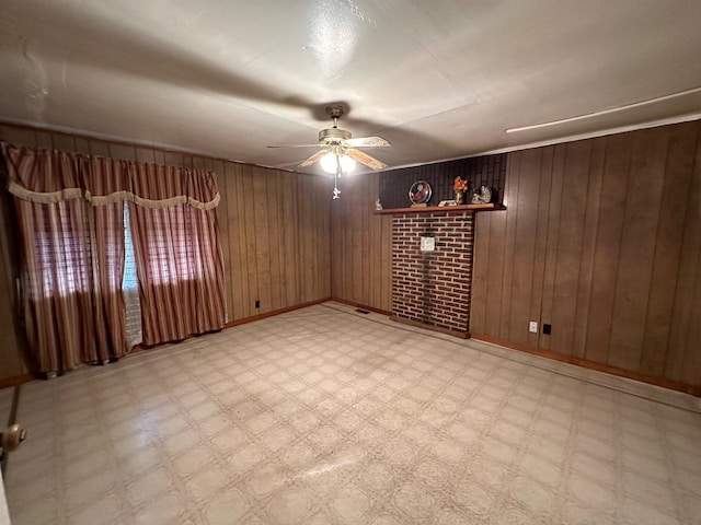 unfurnished room with ceiling fan, wooden walls, and brick wall