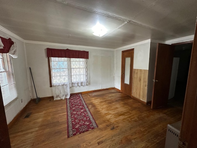 empty room featuring ornamental molding and dark hardwood / wood-style floors