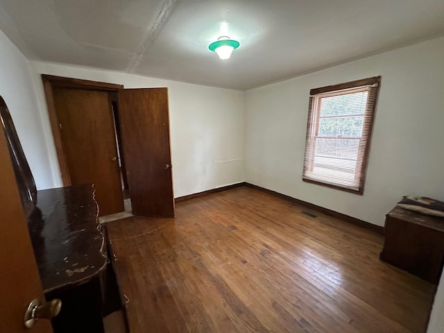 unfurnished bedroom with dark wood-type flooring