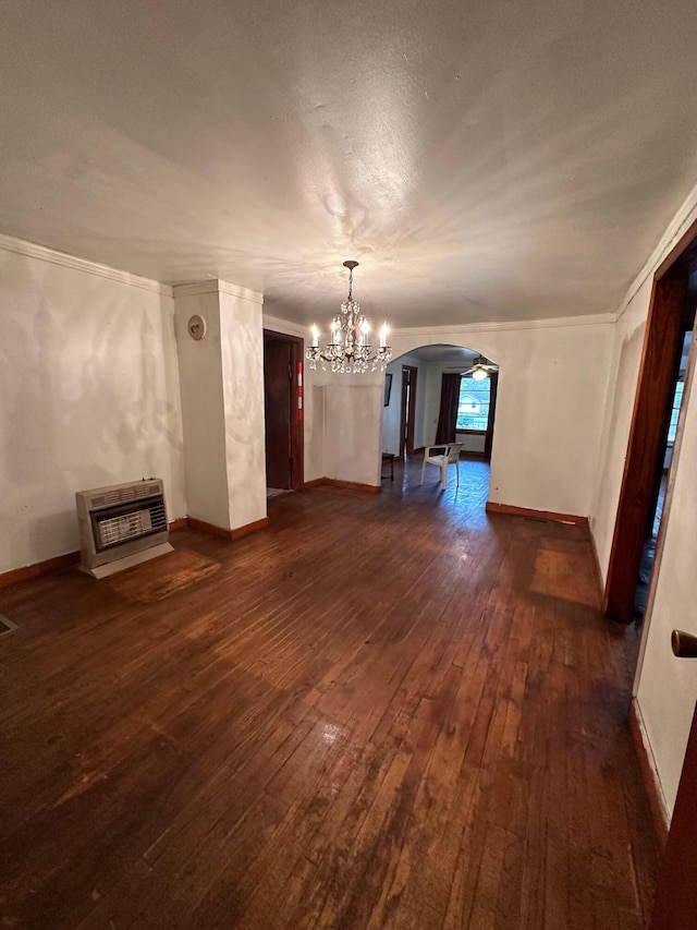 unfurnished room with an inviting chandelier, dark hardwood / wood-style flooring, and ornamental molding