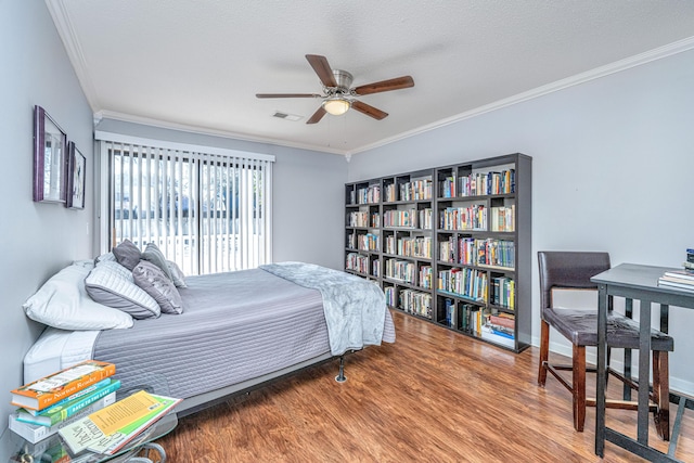 bedroom with hardwood / wood-style flooring, ceiling fan, crown molding, and a textured ceiling