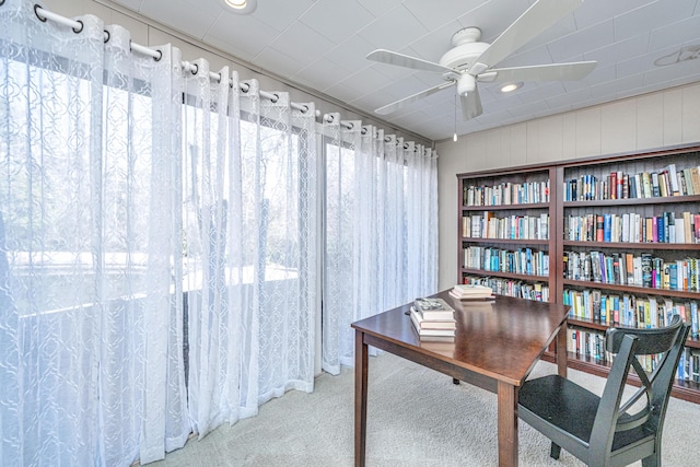 carpeted office space featuring ceiling fan