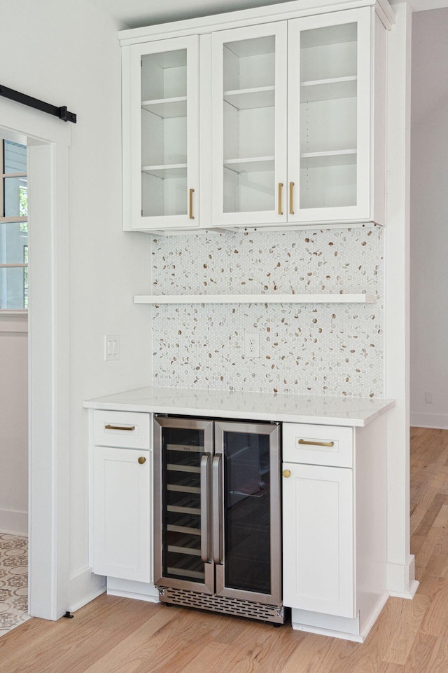 380 Tidal Reef Cir, Mount Pleasant, SC 29464 - indoor dry bar featuring wine cooler, light wood-type flooring, decorative backsplash, and baseboards