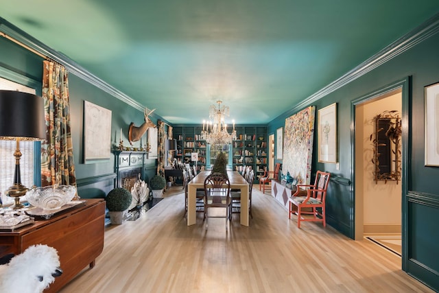 dining room featuring crown molding, baseboards, wood finished floors, and a notable chandelier
