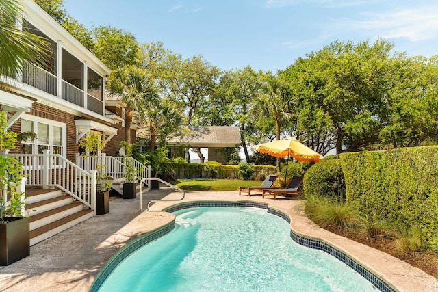 outdoor pool with a patio and a fenced backyard