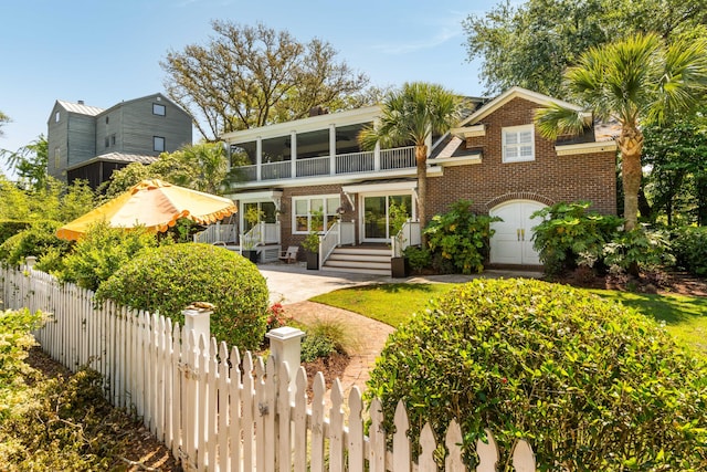 back of property featuring brick siding, fence, and a balcony