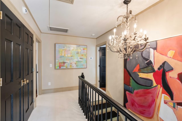 entryway featuring crown molding, baseboards, a chandelier, and visible vents