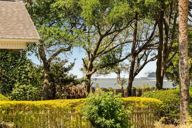 view of yard featuring a water view and fence