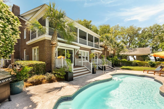 outdoor pool featuring fence and a patio