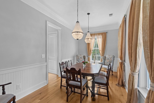 112 Berkshire Dr, Wando, SC 29492 - dining space with an inviting chandelier, wainscoting, light wood-style flooring, visible vents, and ornamental molding