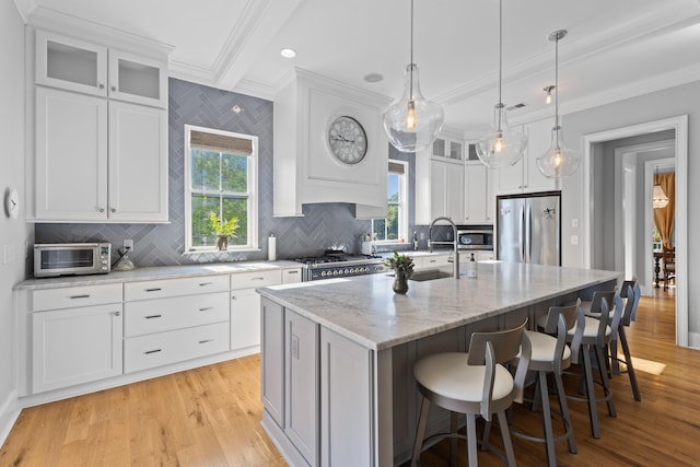 112 Berkshire Dr, Wando, SC 29492 - kitchen with a kitchen island with sink, crown molding, appliances with stainless steel finishes, a sink, and light wood finished floors