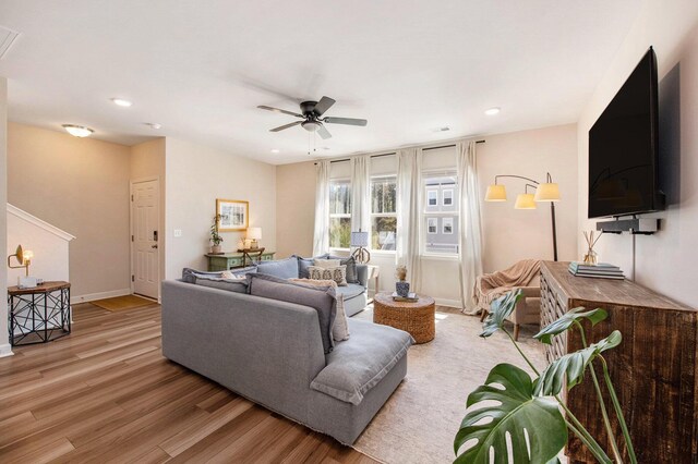 living area with baseboards, light wood-type flooring, recessed lighting, and a ceiling fan