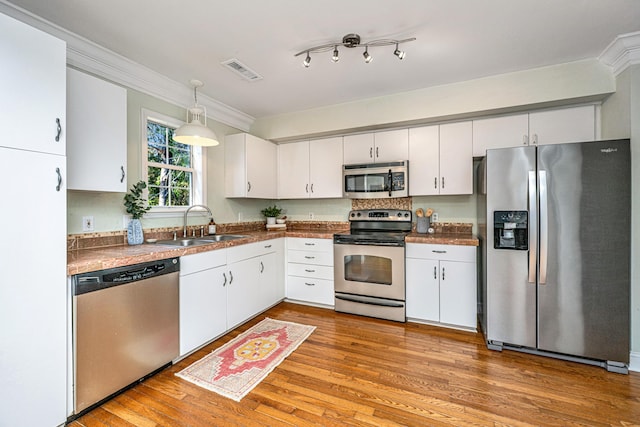 kitchen featuring white cabinetry, stainless steel appliances, and pendant lighting