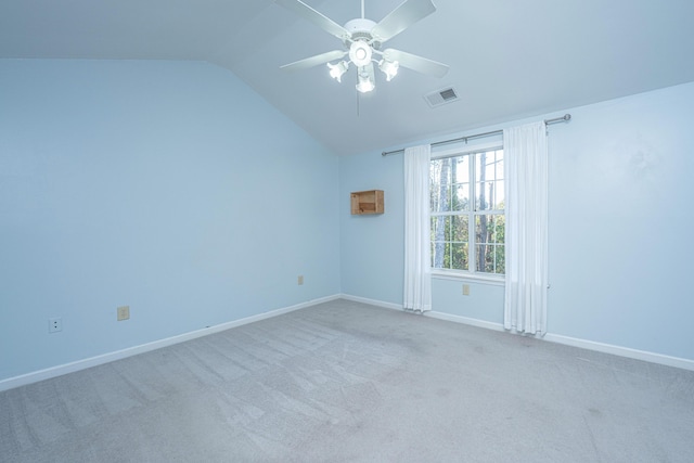 unfurnished room with visible vents, a ceiling fan, light carpet, vaulted ceiling, and baseboards